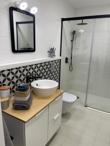 een witte badkamer met een wastafel en een douche bij CÉNTRICO APARTAMENTO REFORMADO EN ARANJUEZ in Aranjuez