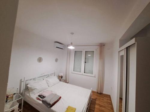 Habitación blanca con cama y ventana en Apartment Matovic en Tesalónica