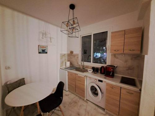 cocina con mesa y lavadora en Apartment Matovic, en Tesalónica