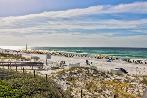 a beach with people and umbrellas and the ocean at Beachwalk Villa 5194 in Destin