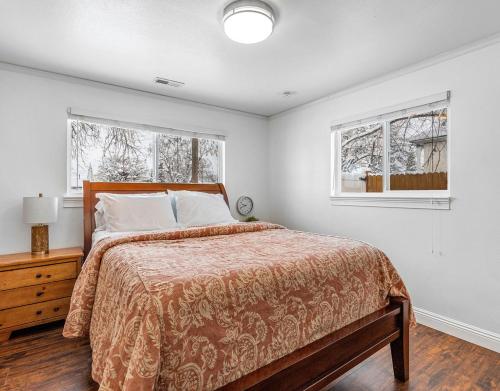 a bedroom with a bed and two windows at Modern home near UVU and BYU with hot tub and mountain views in Orem