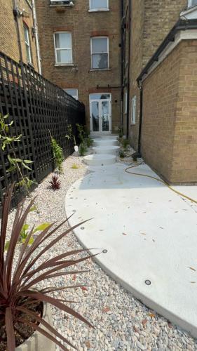 an empty sidewalk in front of a brick building at Cliffs Pavilion 2 Bedroom Apartment in Southend-on-Sea