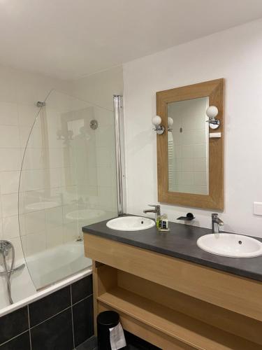 a bathroom with two sinks and a tub and a mirror at Appartement duplex 8 à 10 personnes - Belle Plagne - Pieds de pistes in La Plagne Tarentaise