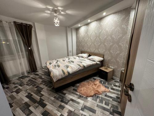 a bedroom with a bed and a rug on the floor at Emm’a in Ploieşti