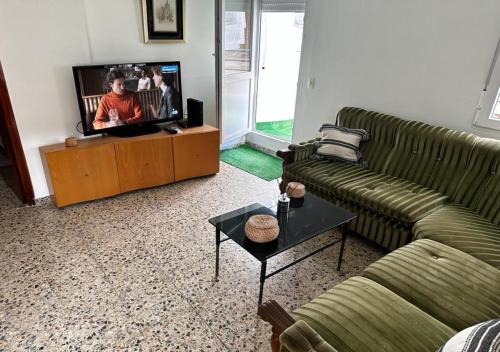 Atico Alma في Jalance: غرفة معيشة مع كنبتين وتلفزيون بشاشة مسطحة