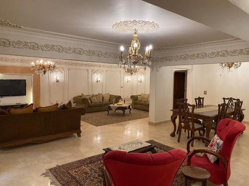 sala de estar con sofá y comedor en Luxurious, fully furnished and well-equipped apartment with modern amenities, stunning views, and convenient location for remote work or studying from home, en El Cairo