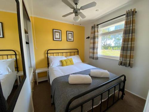 a bedroom with a bed with two pillows on it at East Coast Chalets, Bee’s Knees @ California Sands in Scratby