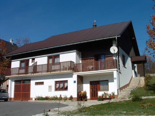 una gran casa blanca con techo negro en Guest House Tone, en Poljanak
