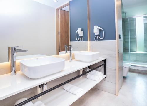 a bathroom with two sinks and a mirror at Almasur Providencia in Santiago