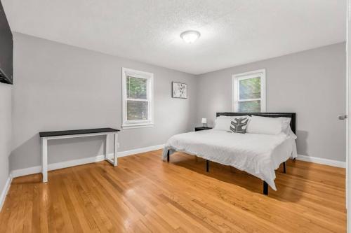 a white bedroom with a bed and a desk at North Haven Charm, 3BD Yale Retreat in North Haven