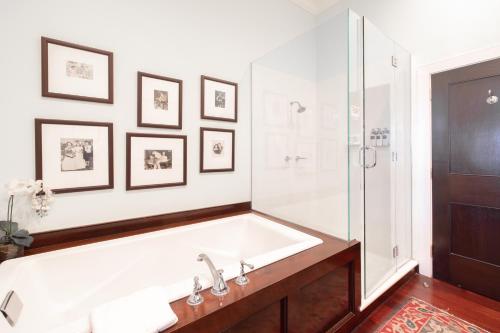 a white bathroom with a tub and a shower at Rhett House in Beaufort