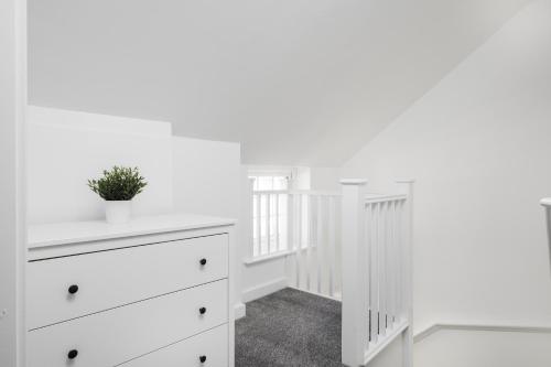 a white room with a dresser and a staircase at Modern 2bed Apartment in Worksop in Worksop