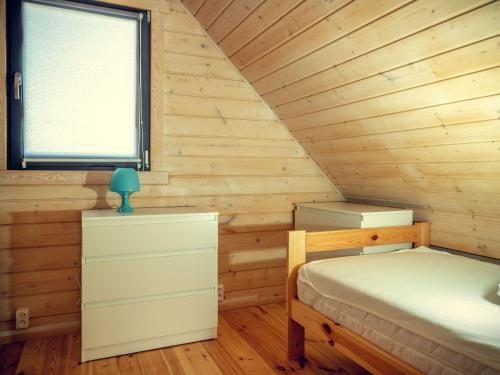 a bedroom with a bed and a window in a log cabin at Cozy family cottages, not far from the sandy beach, in a quiet location, Gaski in Gąski