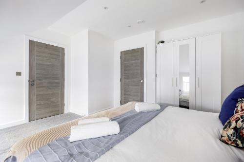 Un dormitorio blanco con una cama grande con toallas. en Modern 2bed Apartment in Worksop, en Worksop