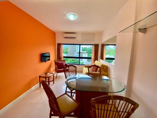 a living room with a glass table and chairs at Ondina Apart Hotel Residences in Salvador