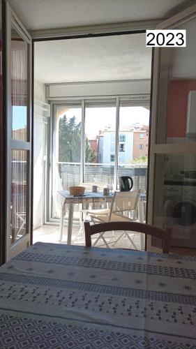 une chambre avec un lit et un balcon avec une table dans l'établissement Lara 1 - Grand T2 Loggia Sans vis-à-vis Parking - Près centre-port, île des Loisirs, plage Richelieu, au Cap d'Agde