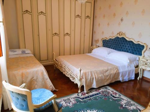 1 dormitorio con 2 camas, silla y silla en Patrizia's Maison, en Ripatransone