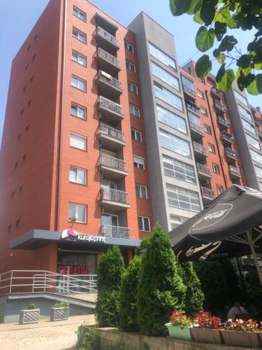 un edificio de apartamentos con una sombrilla delante de él en My place, en Pristina