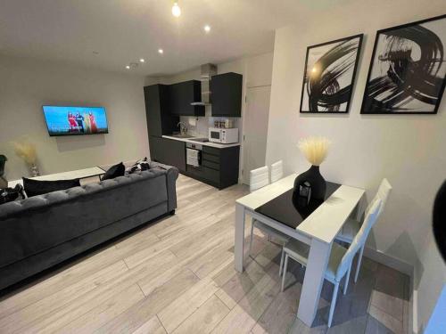 a living room with a black couch and a table at Stylish and Cosy 2 bedroom flat in Croydon in Croydon