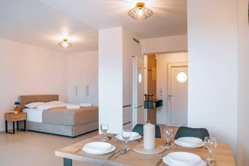 een kamer met een eettafel en een slaapkamer bij Grand White Apartments in Agios Ioannis