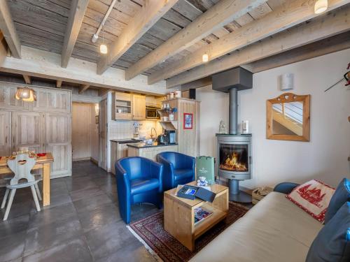 un salon avec un canapé et une cheminée dans l'établissement Appartement cosy au pied des pistes avec mezzanine, poêle à bois et services inclus pour 4 personnes - FR-1-570-28, à Saint-Martin-de-Belleville