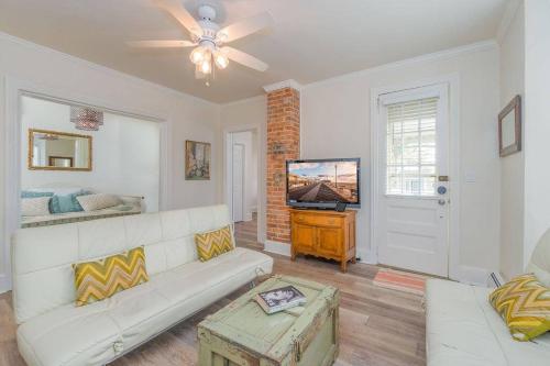 a living room with a white couch and a tv at The Stockton - Victorian Ocean Grove near Asbury in Ocean Grove