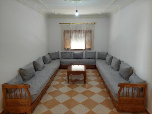 un soggiorno con un grande divano e un tavolo di Oued Laou Noor - Sunborn Holidays a Oued Laou