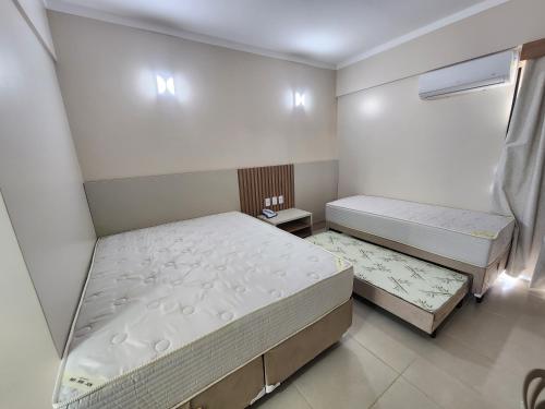 a bedroom with two beds and a window at Spazzio diRoma - Apartamentos JN in Caldas Novas