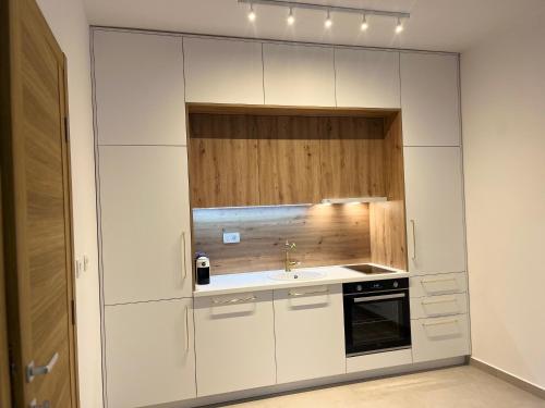 a kitchen with white cabinets and a sink at Apartments Doclea in Podgorica