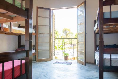 a room with bunk beds and a balcony at Sambaqui Hostel in Ilhabela