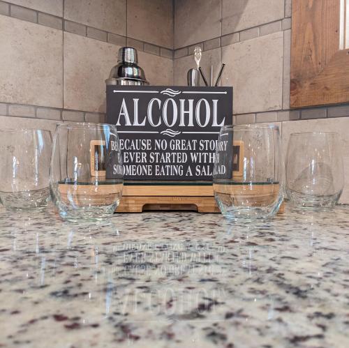 a group of wine glasses sitting on a table at Wine Time 5 Bedroom Shuffleboard Hot Tub Fire Pit Play Set in Broken Bow