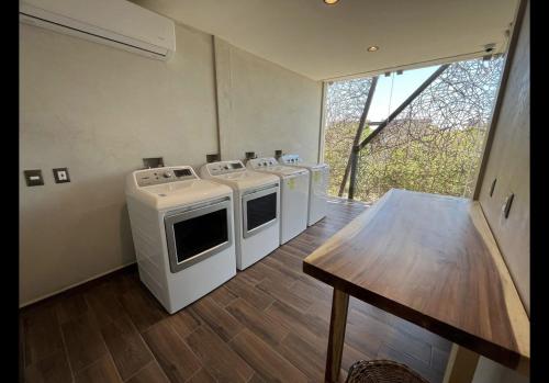 une cuisine avec des appareils blancs et un parquet dans l'établissement Charming studio Akua Tulum Aldea Zama Premium, à Tulum