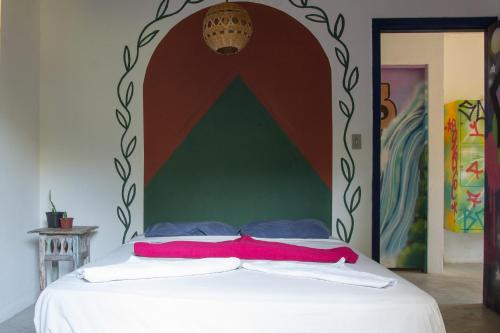 a bedroom with a bed with a large headboard at Sambaqui Hostel in Ilhabela