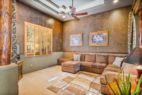 a living room with a couch and a ceiling fan at Quail Mountain Desert Resort: Heated Pool, Mt Vews, all BR's King & TV's, Hiking in Mesa