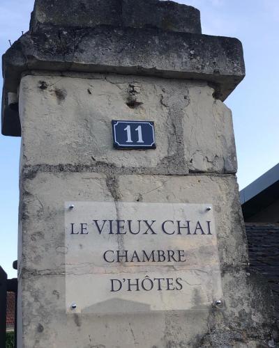 a sign on the side of a brick wall with a sign at Le VIEUX CHAI in Souzay-Champigny