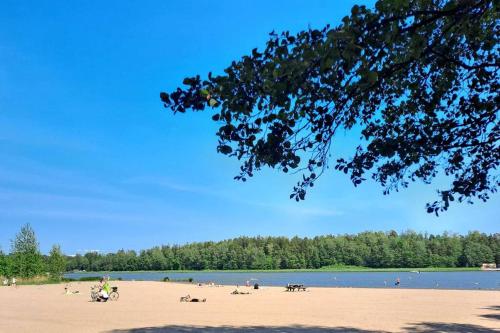 a beach with people on the sand and water at Puotilan idylli meren lähellä in Helsinki