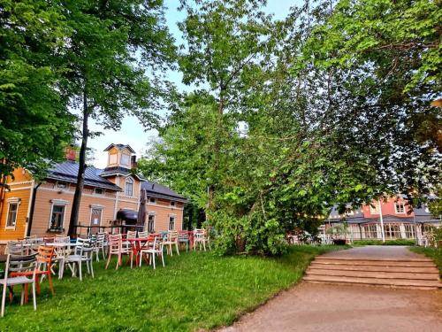 um grupo de mesas e cadeiras em frente a um edifício em Puotilan idylli meren lähellä em Helsinque