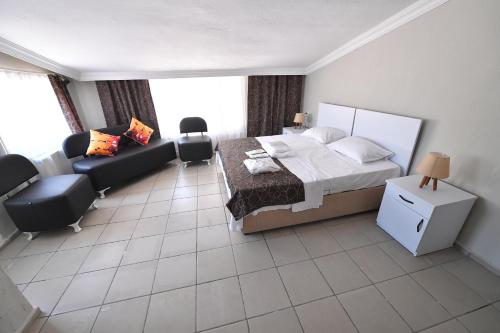 1 dormitorio con 1 cama y sala de estar con sofá en Nilhan Otel en Ören