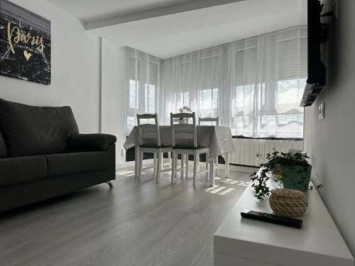 a living room with a table and chairs and a couch at Apartamento Temático Cantabria in Camargo