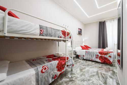 una camera con 2 letti a castello con lenzuola rosse e bianche di Elite del Centro Storico a Napoli