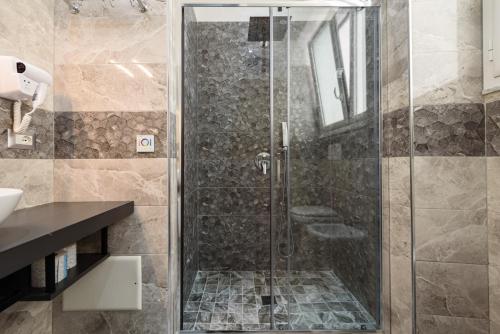 una doccia con porta in vetro in bagno di Elite del Centro Storico a Napoli