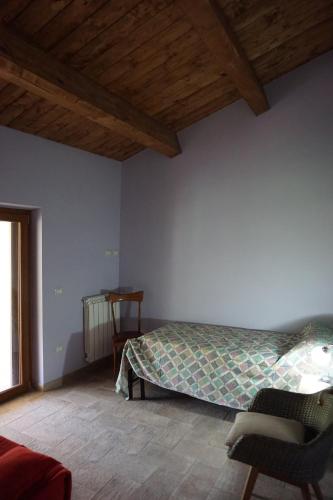 a bedroom with a bed and a chair in a room at Le Gatte in SantʼUrbano