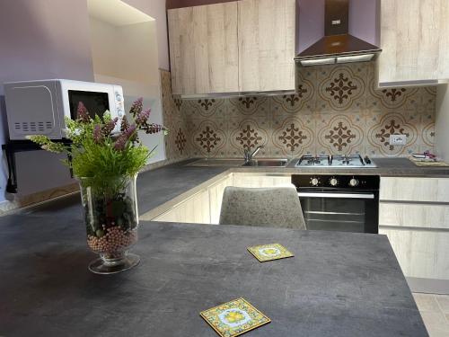 a kitchen with a vase of flowers on a table at Le Gatte in SantʼUrbano