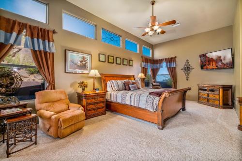 a bedroom with a bed and a chair at Quail Mountain Desert Resort: Heated Pool, Mt Vews, all BR's King & TV's, Hiking in Mesa