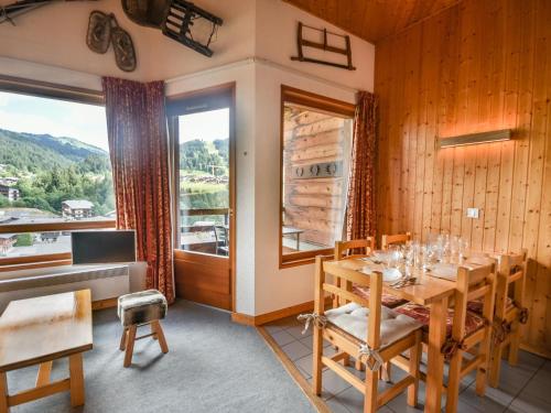 une salle à manger avec une table et une grande fenêtre dans l'établissement T2 duplex 5 pers aux Gets, proche centre, parking et tennis - FR-1-685-23, aux Gets