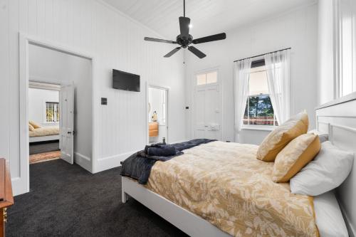 a bedroom with a bed and a ceiling fan at The Bank House Ulmarra in Ulmarra