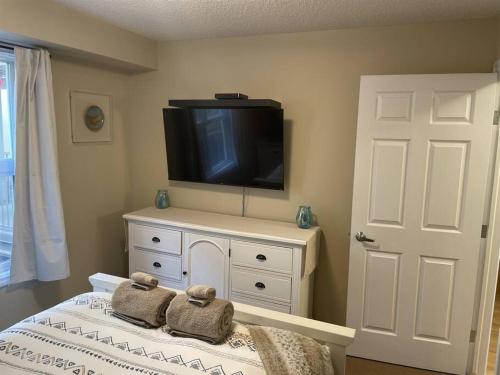 a bedroom with a tv on top of a dresser at Chris's Cozy Condo Times Square Rogers Place Edmonton in Edmonton