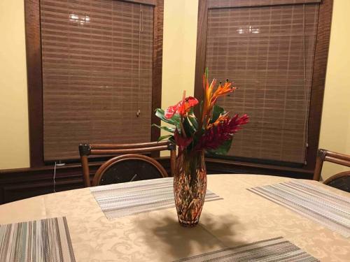 a vase filled with flowers sitting on a table at Hawaii Tropical Volcano mansion + Sauna in Hilo