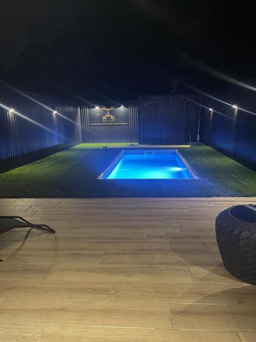una piscina illuminata di notte con luci di Spalace a Cuincy