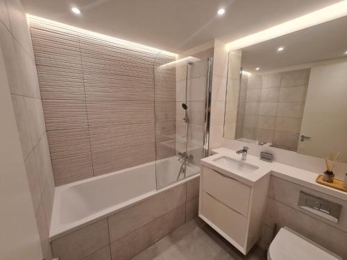 ジブラルタルにあるLuxury Apartment in Eurocityの浴槽、洗面台、シャワーを備えたバスルーム